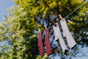 set of various socks drying on rope in backyard